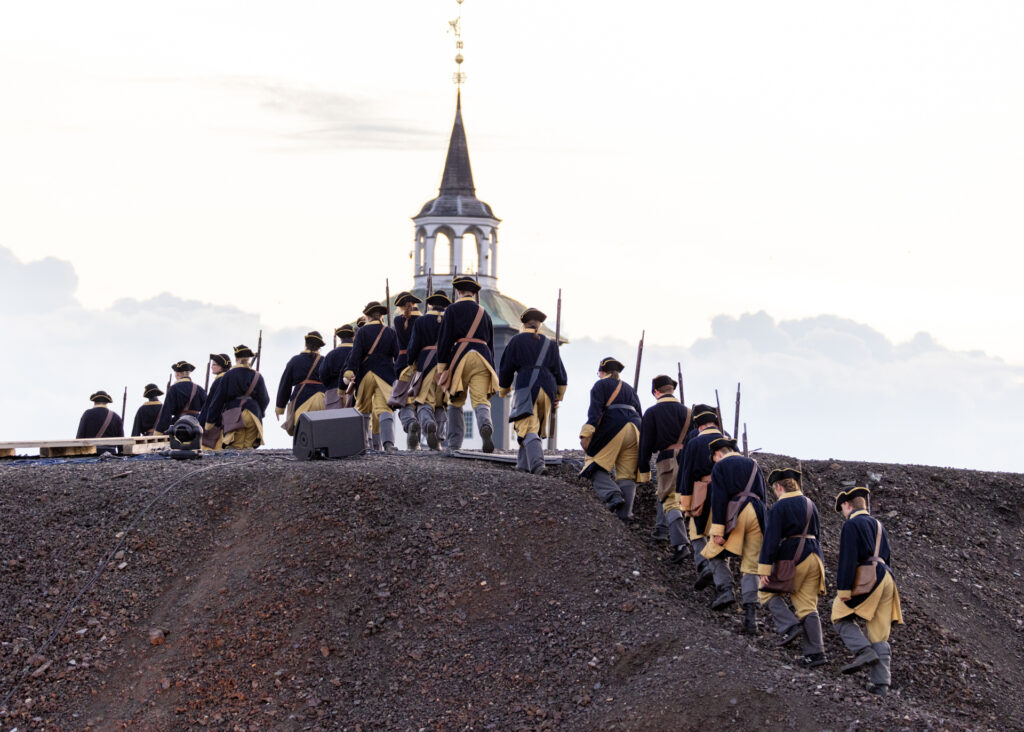 Bilde av Karolinerne som marsjerer over Slegghaugan mot Røroskirken.